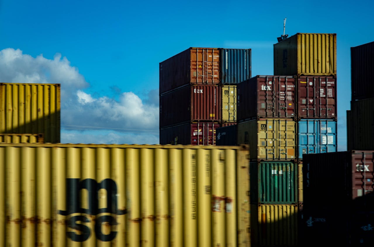 gallery-5 A vibrant display of stacked cargo containers against a clear blue sky.