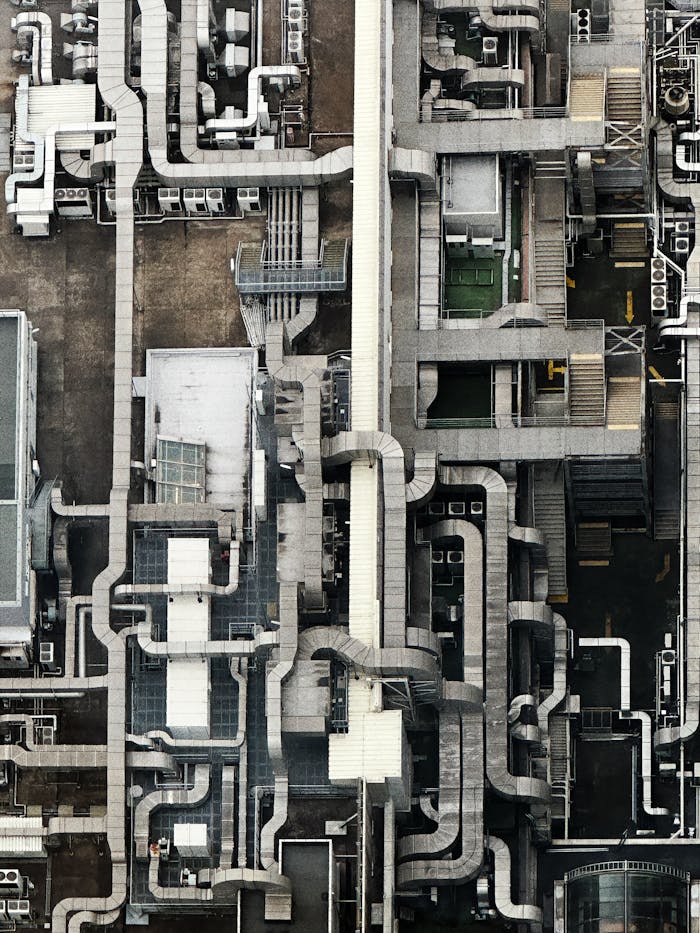 Aerial view showing an intricate network of industrial pipes and structures on a rooftop.
